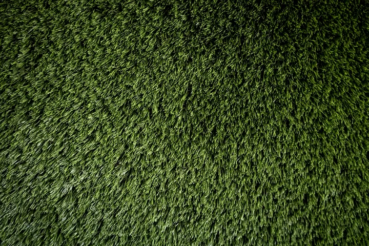 Close-up of dense artificial grass fibres standing upright